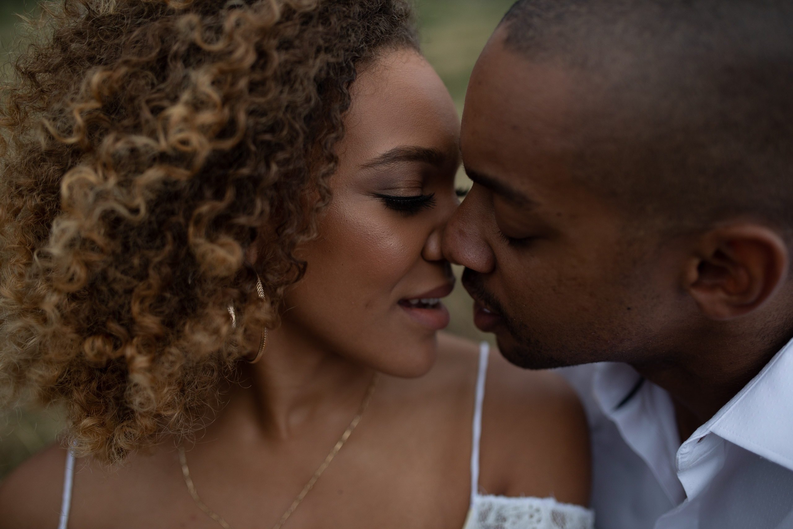 Romantic black couple with curly hair leaning in for a kiss on wedding day intimate moment bride and groom