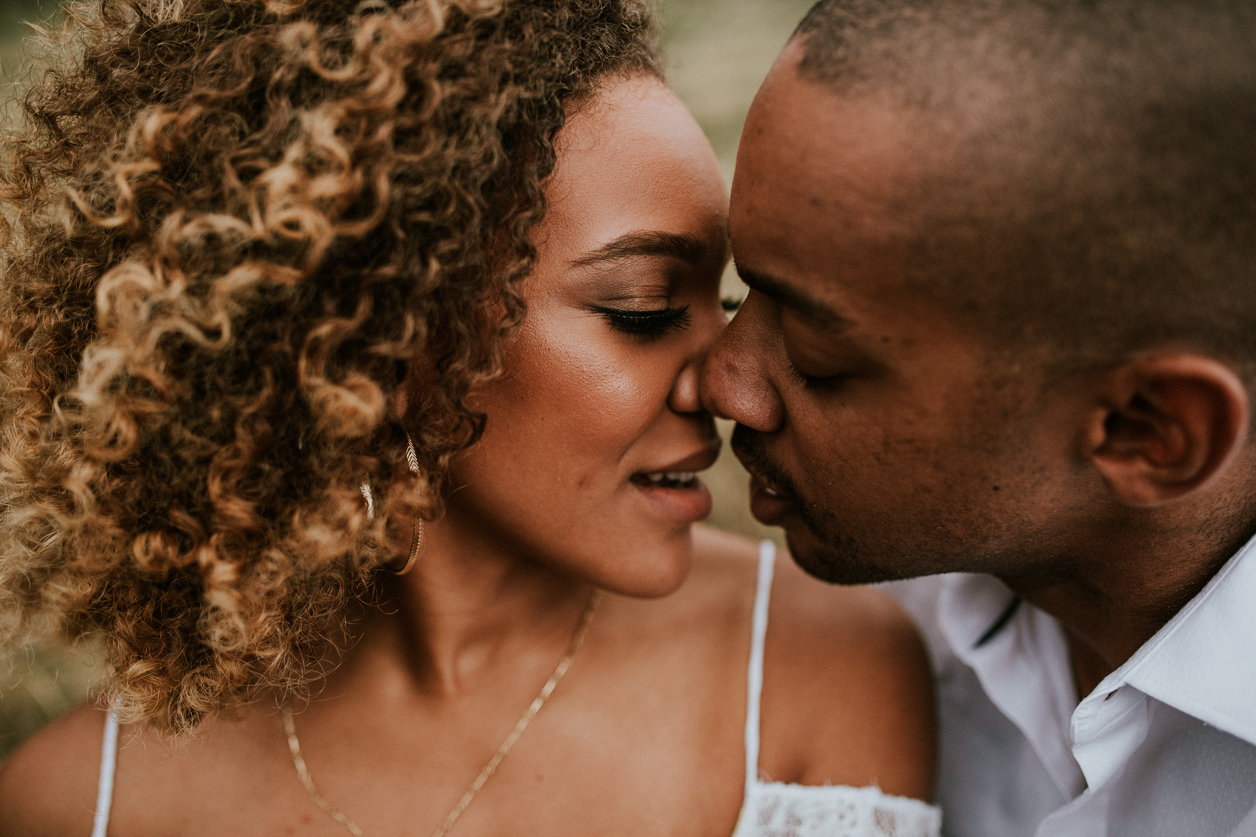 Romantic black couple with curly hair leaning in for a kiss on wedding day intimate moment bride and groom